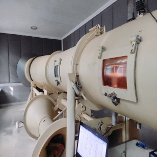 person using crane to move industrial gear box in engineering factory